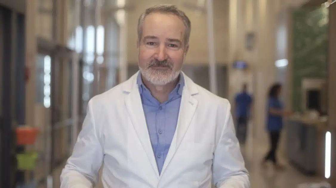 Dr. Shaun Larsen, O.D., smiling in a white coat at the clinic